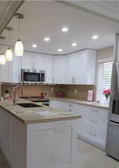Kings Point Piedmont Delray Beach, FL 33484 - Photo 2 of 22 a kitchen with kitchen island granite countertop a sink a stove and cabinets