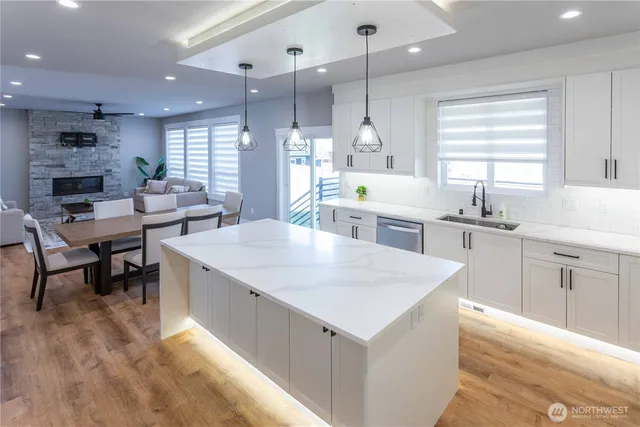 a large kitchen with stainless steel appliances kitchen island granite countertop a refrigerator and a stove top oven