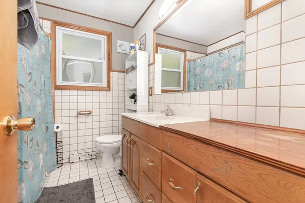 a bathroom with a sink a toilet a mirror and shower