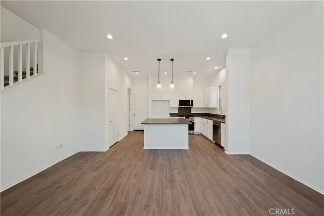 a large kitchen with stainless steel appliances kitchen island a large counter top and a stove top oven