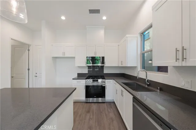 a kitchen with granite countertop white cabinets and white appliances