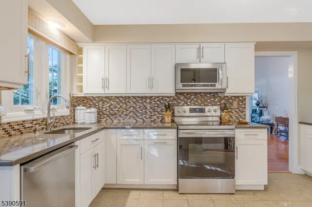 a kitchen with white cabinets sink and stainless steel appliances