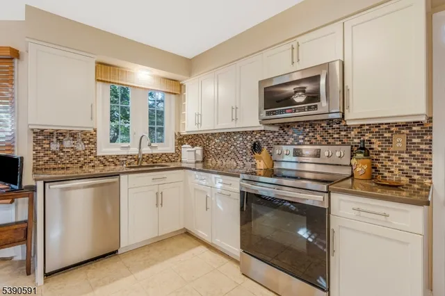 a kitchen with granite countertop a stove sink and microwave