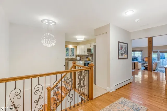 a view of a hallway with wooden floor and stairs