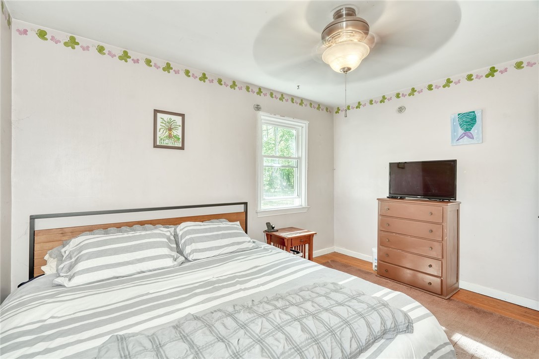 606 Bay Road Webster, NY 14580 - Photo 22 of 49 First floor primary bedroom with hardwood flooring