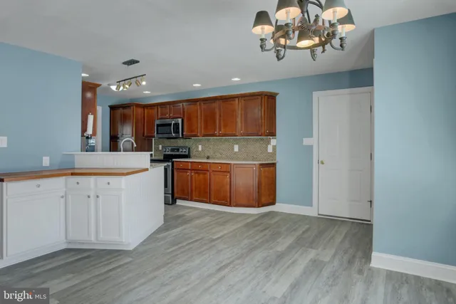 a kitchen with stainless steel appliances granite countertop a stove a sink dishwasher and a refrigerator
