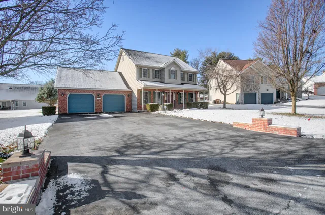 a view of a white house with a yard covered in snow