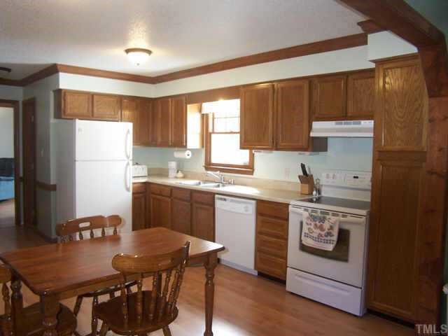 5321 Ridgeloch Place Raleigh, NC 27612 - Photo 6 of 10 a kitchen with a refrigerator a stove a sink and a dining table
