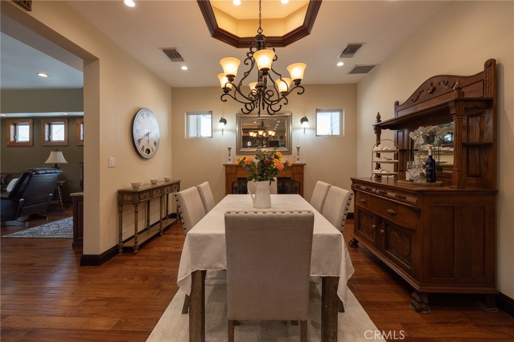 6071 Sun View Road Yorba Linda, CA 92886 - Photo 8 of 49 a dining room with wooden floor a chandelier a flat screen tv and a chandelier