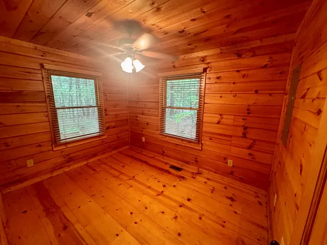 a view of empty room with fireplace and wooden floor
