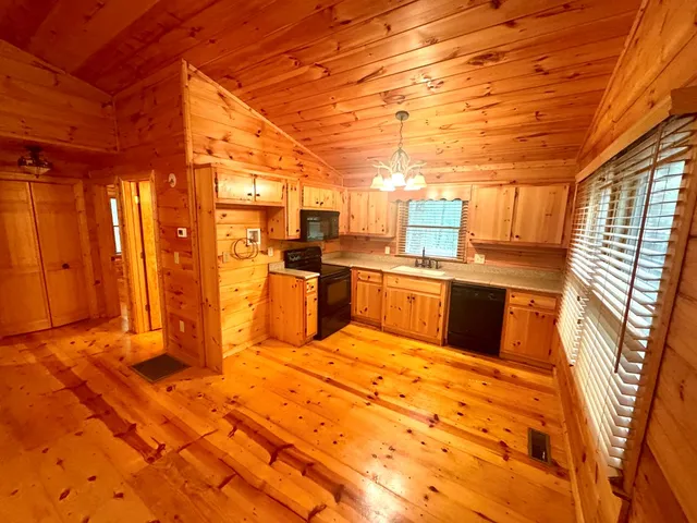 a large kitchen with stainless steel appliances granite countertop a sink and cabinets