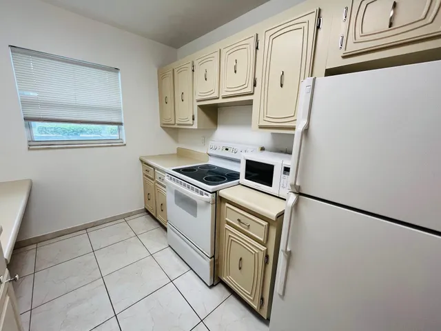 a kitchen with white cabinets and white appliances