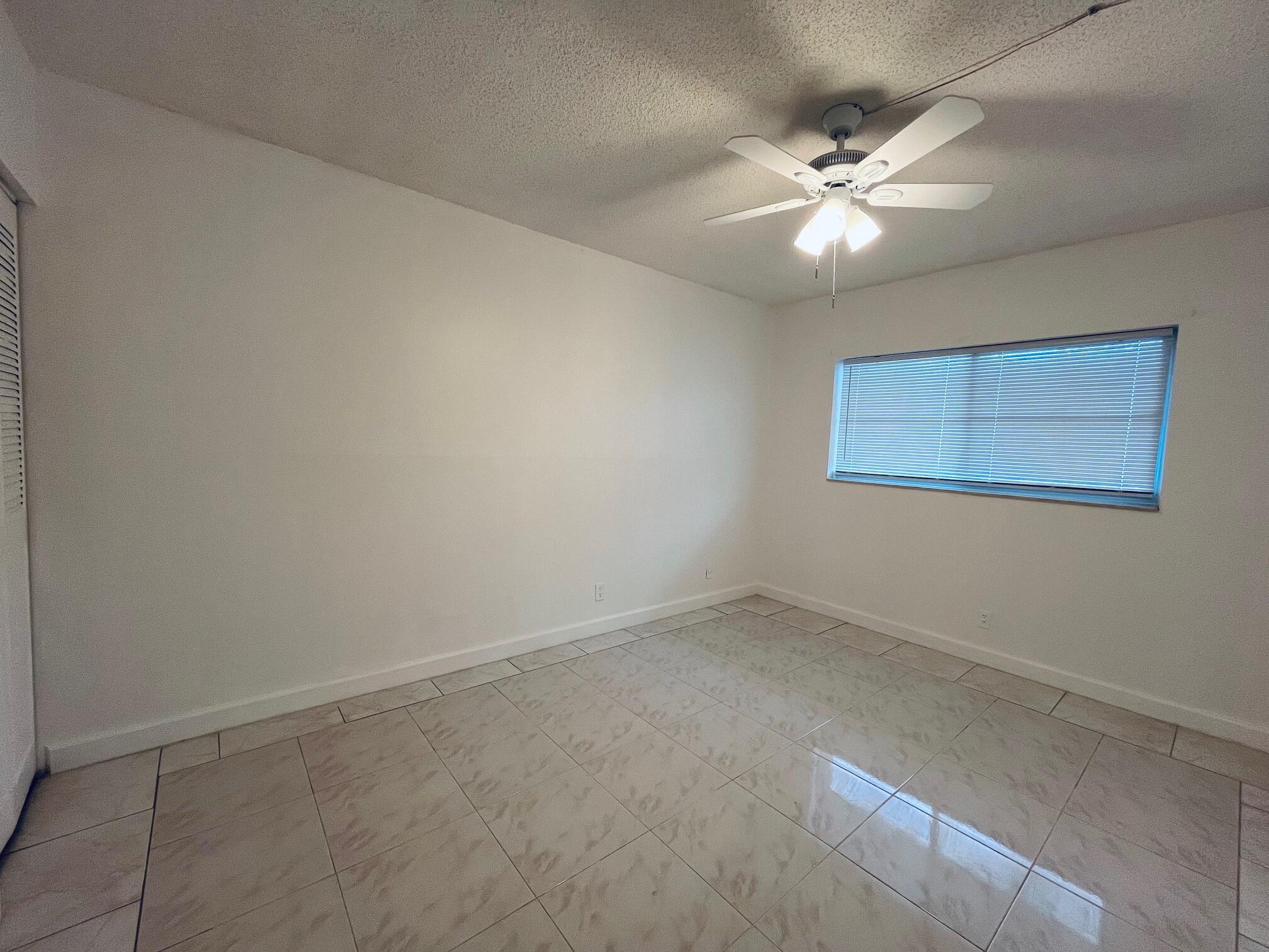 2600 Southwest 22nd Avenue, Unit 903 Delray Beach, FL 33445 - Photo 12 of 27 an empty room with a fan & a window