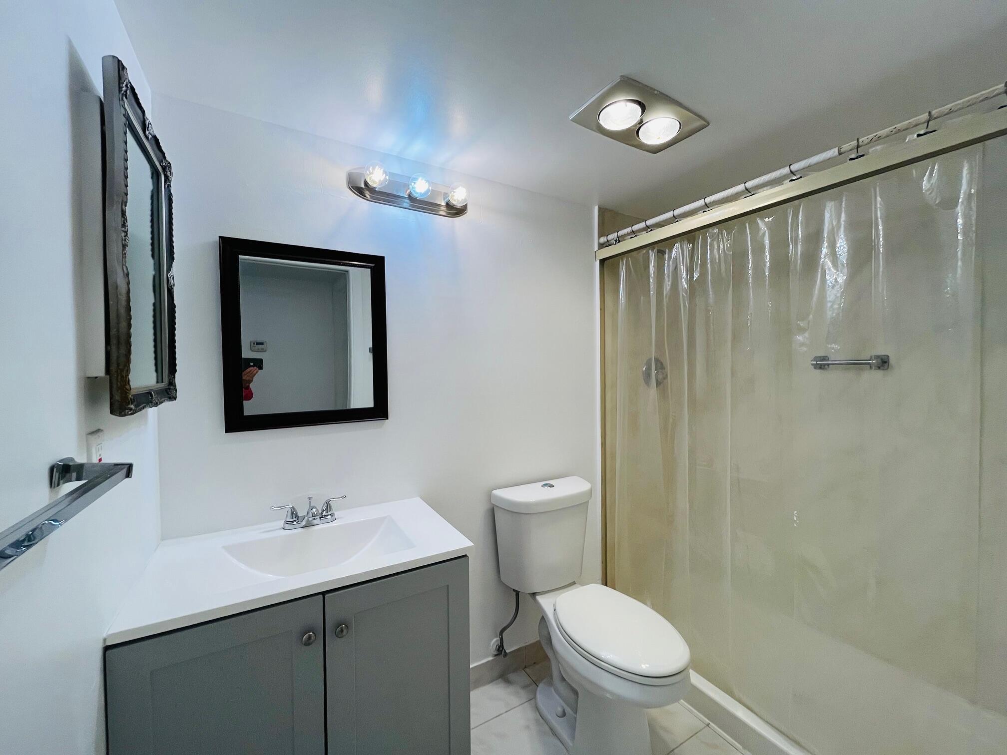 2600 Southwest 22nd Avenue, Unit 903 Delray Beach, FL 33445 - Photo 13 of 27 a bathroom with a toilet a sink and mirror