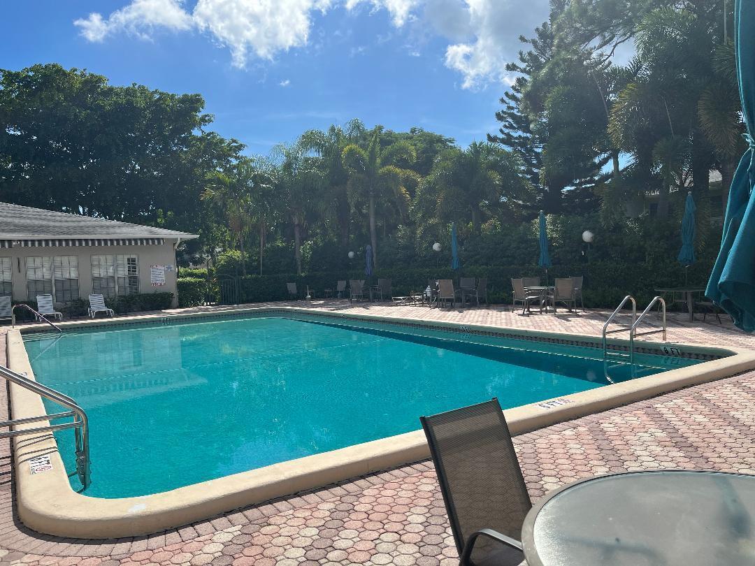 2600 Southwest 22nd Avenue, Unit 903 Delray Beach, FL 33445 - Photo 20 of 27 a view of a swimming pool with a patio and a yard