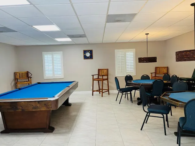 a room with furniture pool table gym equipment and a window
