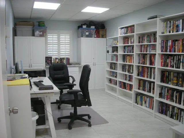 a view of a workspace with furniture and a bookshelf