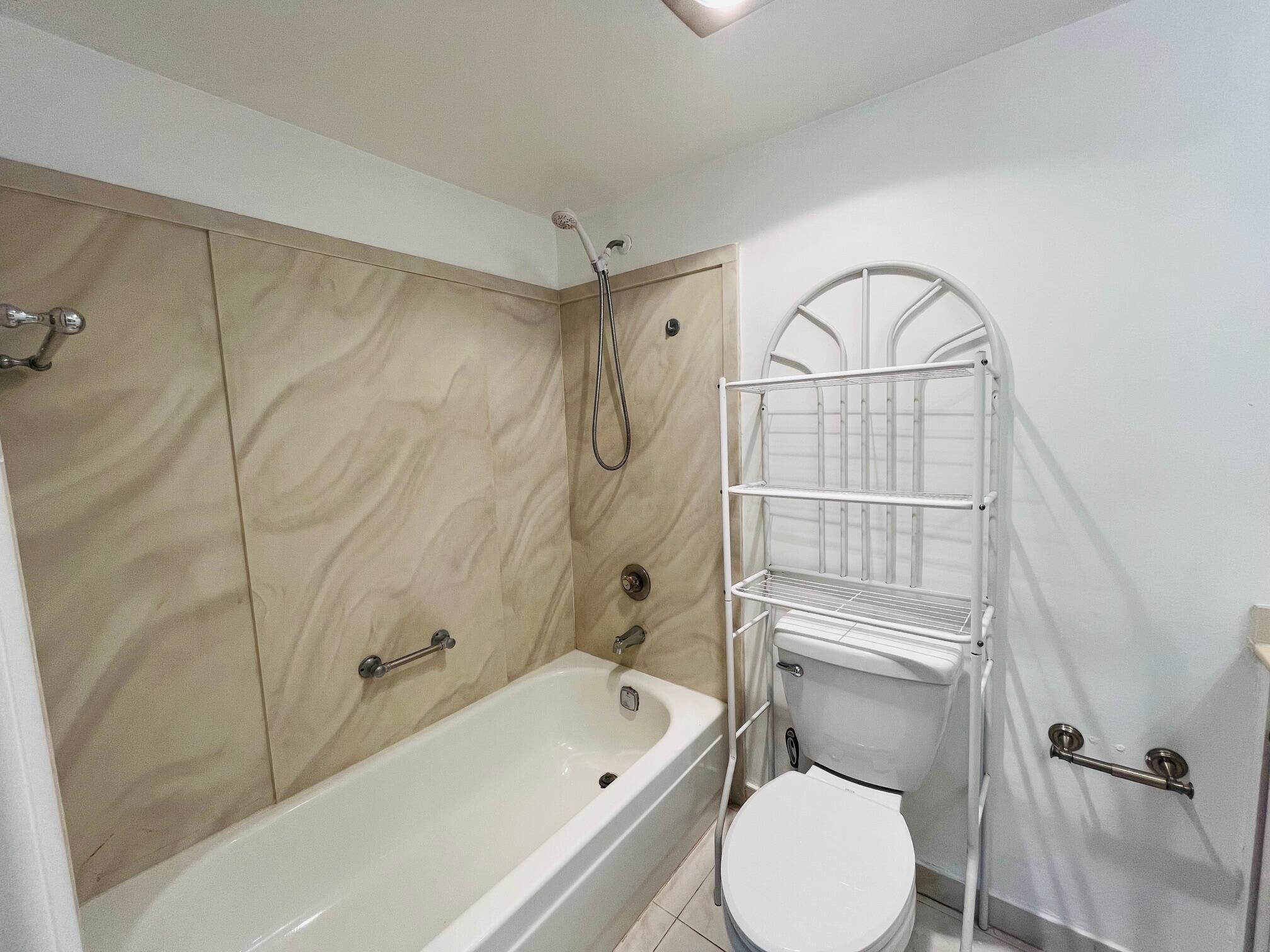 2600 Southwest 22nd Avenue, Unit 903 Delray Beach, FL 33445 - Photo 7 of 27 a bathroom with a toilet sink vanity and tub