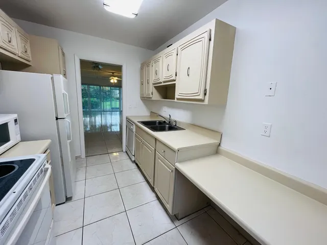 a kitchen with a sink cabinets and wooden floor