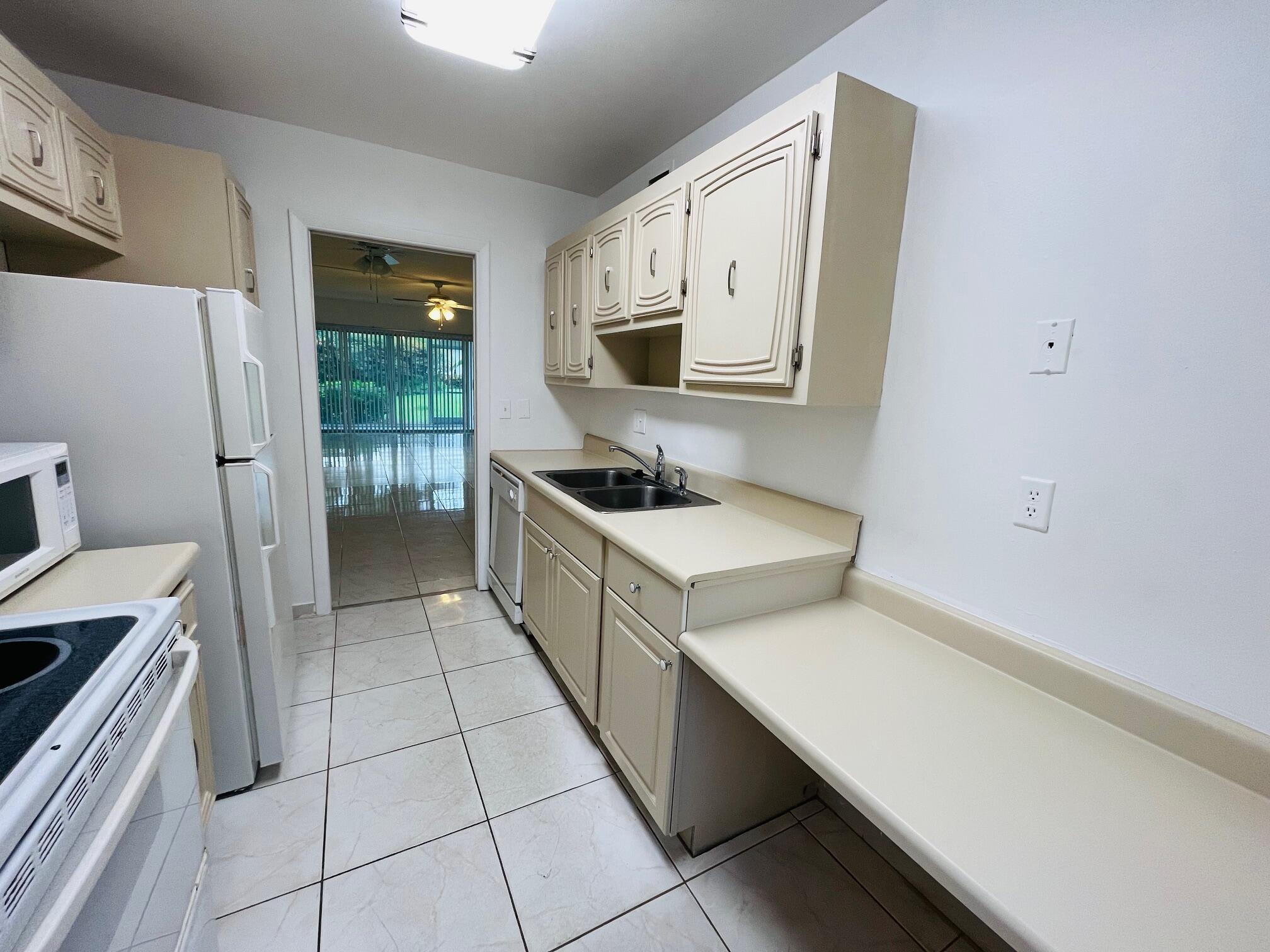 2600 Southwest 22nd Avenue, Unit 903 Delray Beach, FL 33445 - Photo 10 of 27 a kitchen with a sink cabinets and wooden floor