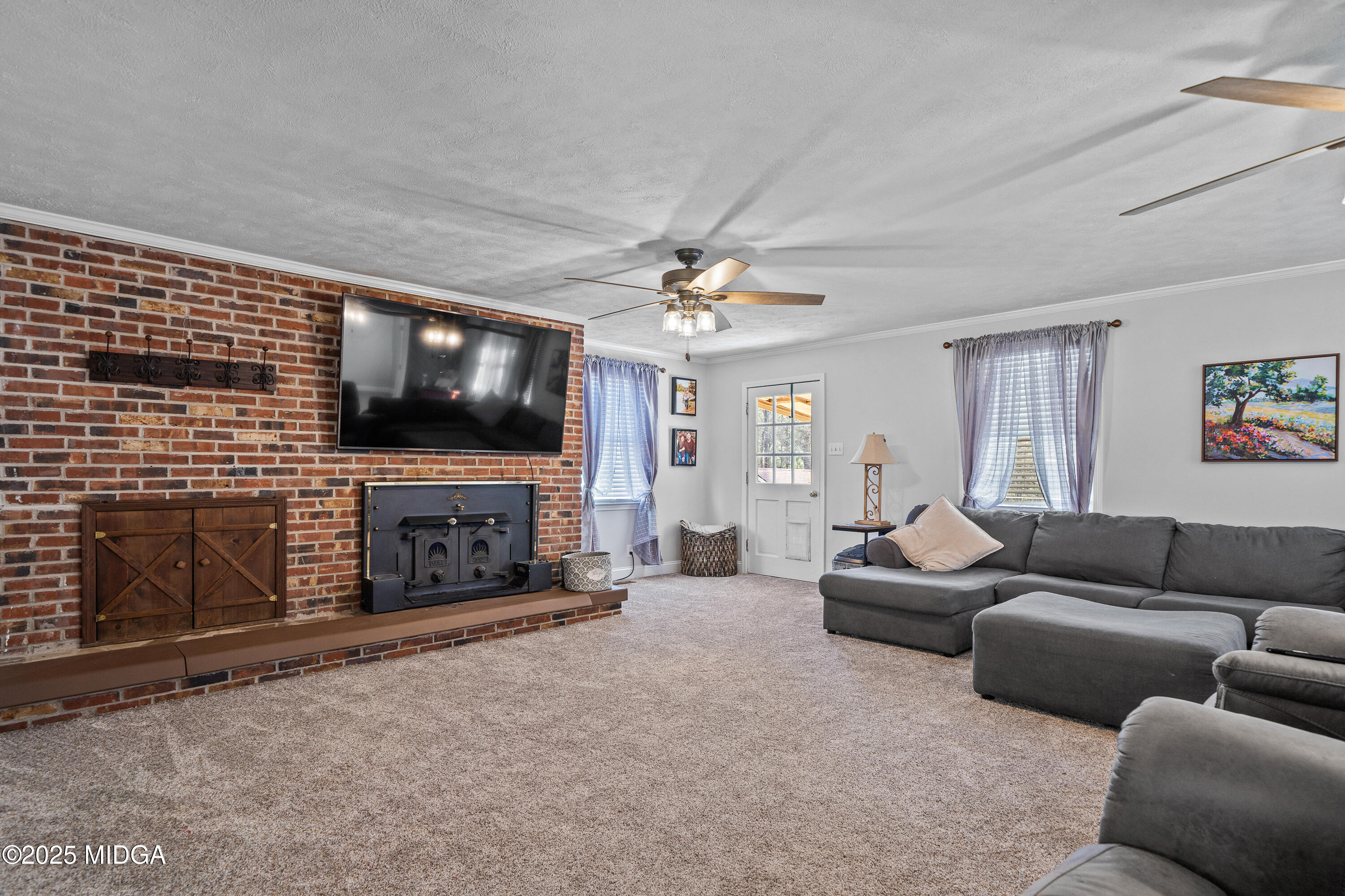 184 Camelot Road Gray, GA 31032 - Photo 19 of 38 a living room with furniture a fireplace and a flat screen tv