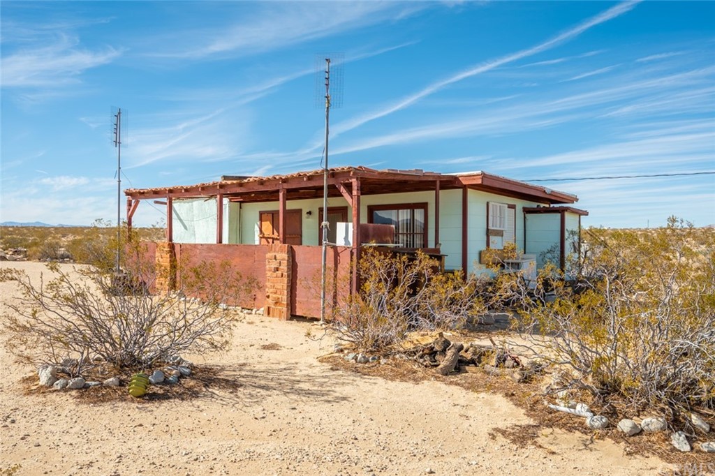 736 Copper Mountain Road Joshua Tree, CA 92252 - Photo 1 of 28 a front view of a house with a yard