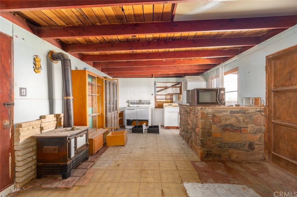 736 Copper Mountain Road Joshua Tree, CA 92252 - Photo 11 of 28 a living room with patio furniture and a fireplace