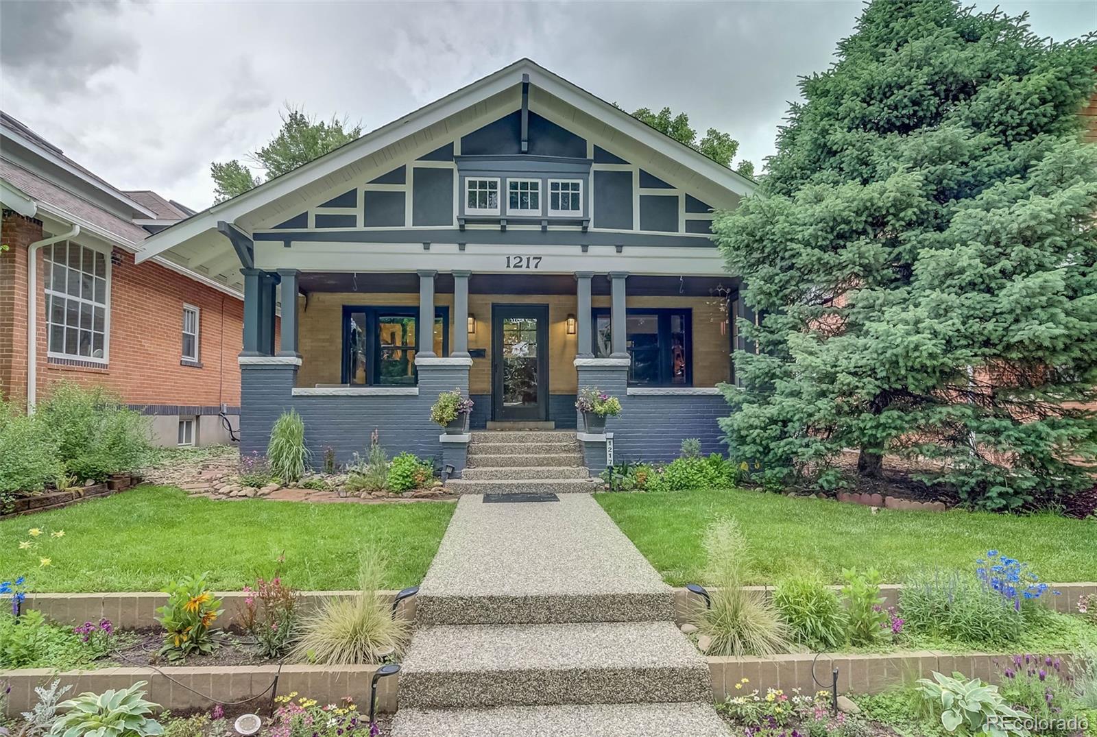 a front view of a house with a yard and trees