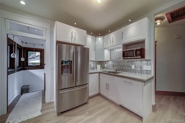 a kitchen with stainless steel appliances granite countertop a refrigerator and a stove top oven