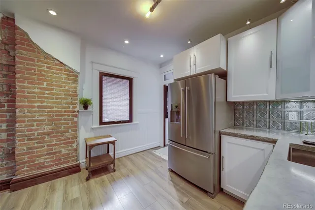 a kitchen with stainless steel appliances granite countertop a refrigerator a stove and a wooden floors