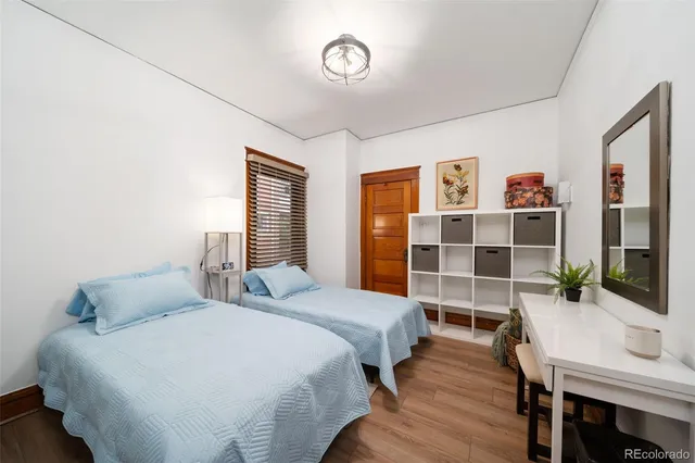 a bedroom with a bed and a bookshelf with wooden floor