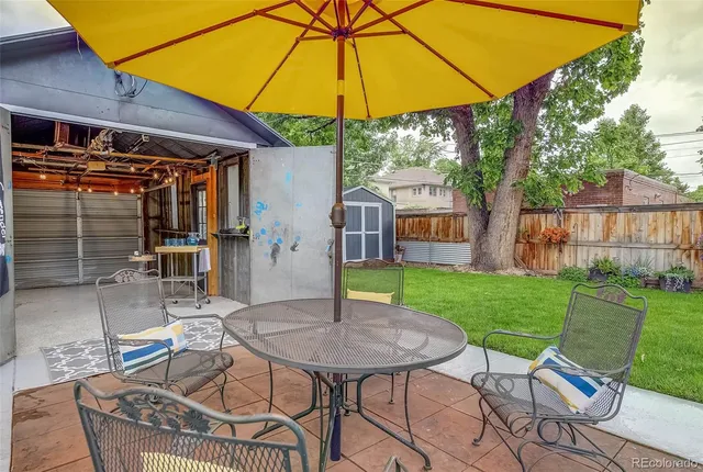 a patio with a table and chairs under an umbrella
