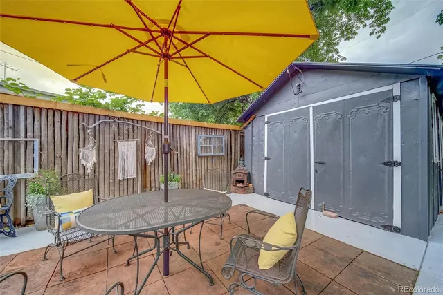 a backyard of a house with table and chairs