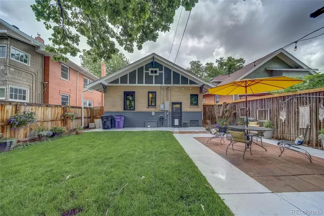 a patio with a table and chairs under an umbrella