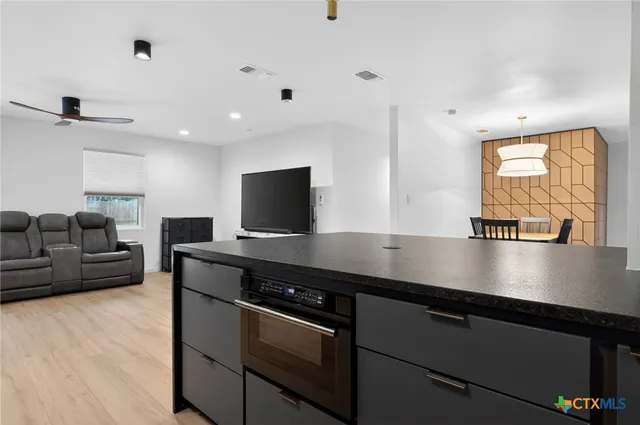 a view of kitchen with stainless steel appliances sink stove and microwave