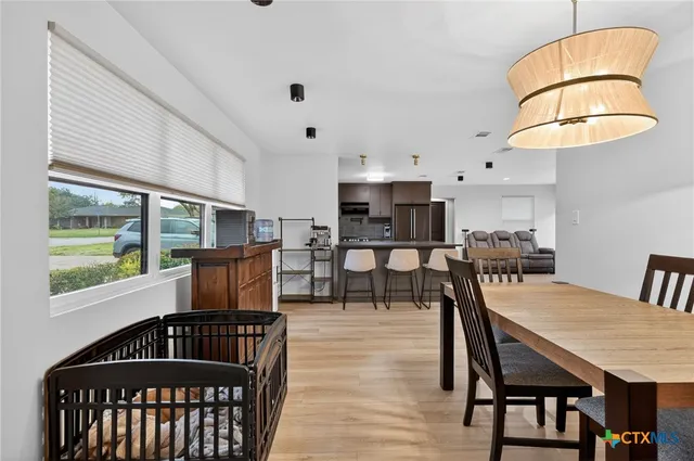 a dining room with furniture a chandelier and wooden floor