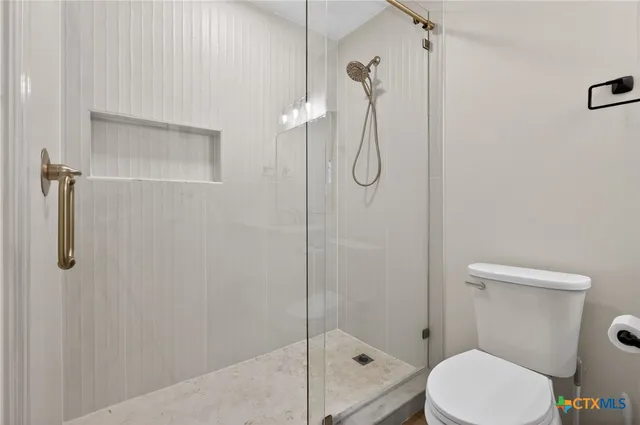 a bathroom with a toilet and a shower