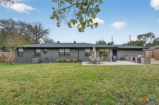 a view of a house with backyard and sitting area