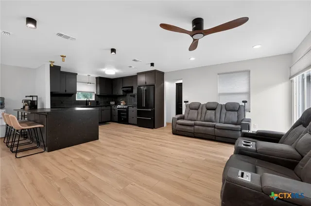 a living room with furniture and kitchen view