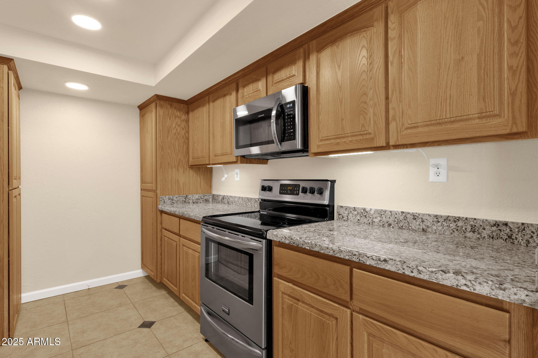 3825 East Camelback Road, Unit 120 Phoenix, AZ 85018 - Photo 10 of 39 a kitchen with stainless steel appliances granite countertop a stove a sink and a microwave