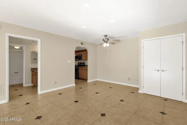 an empty room with a chandelier fan