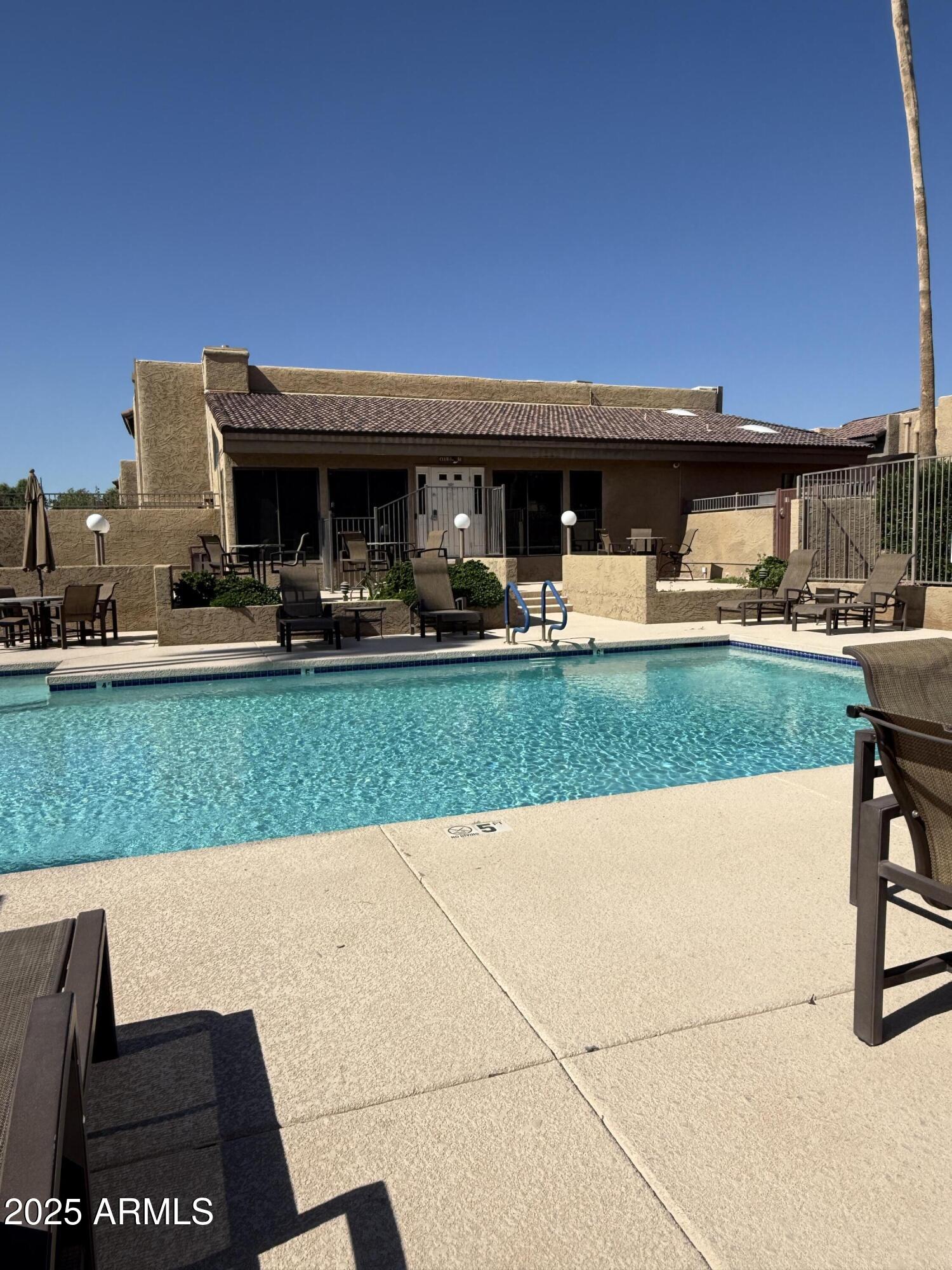 3825 East Camelback Road, Unit 120 Phoenix, AZ 85018 - Photo 34 of 39 a view of a patio with table and chairs under an umbrella