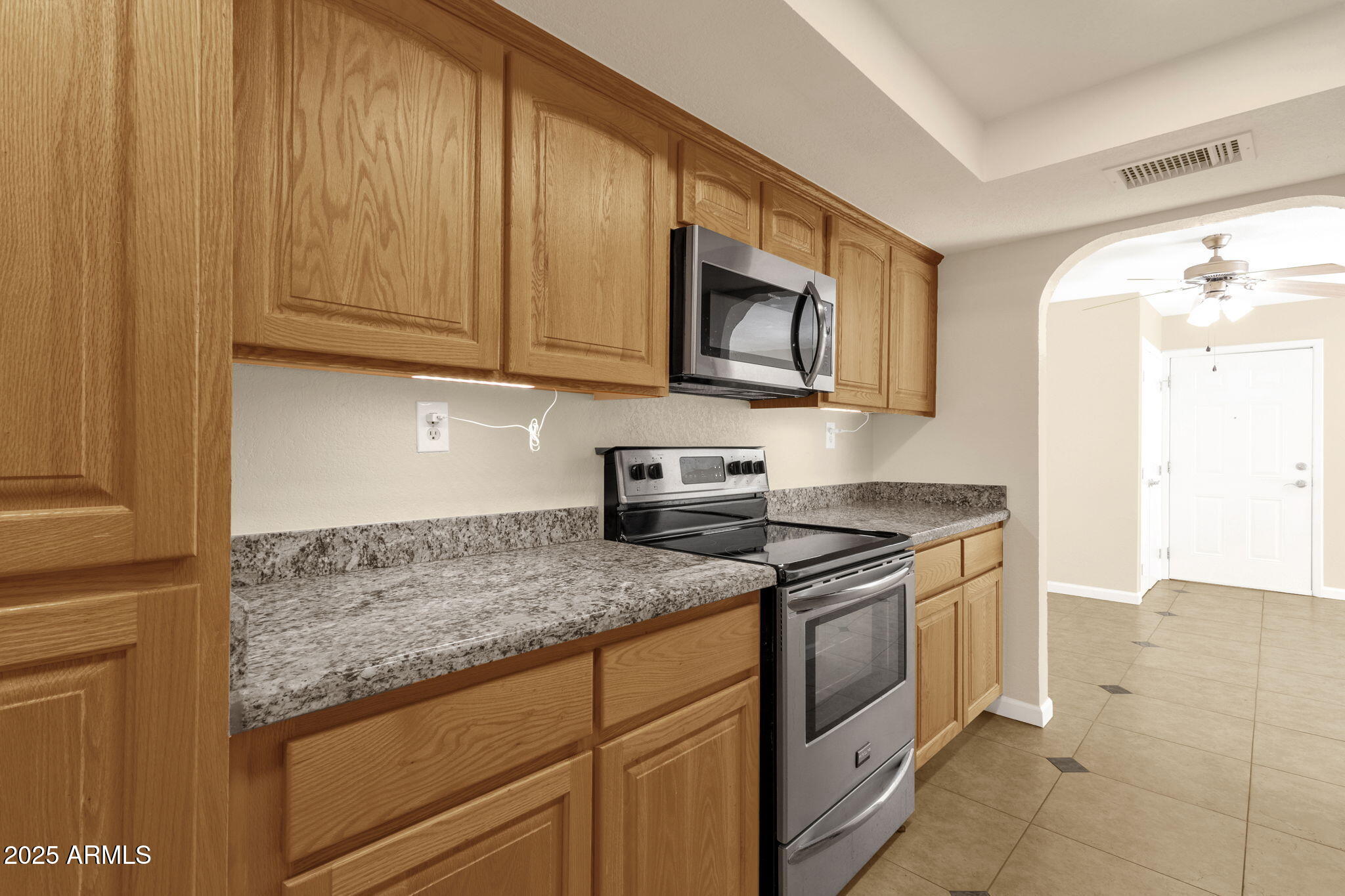 3825 East Camelback Road, Unit 120 Phoenix, AZ 85018 - Photo 9 of 39 a kitchen with stainless steel appliances granite countertop a stove a sink and a microwave