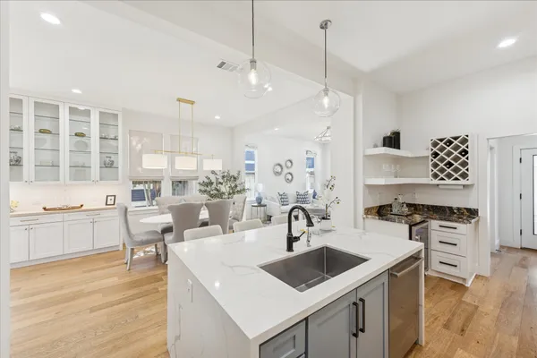 a kitchen with a sink stove and wooden floor
