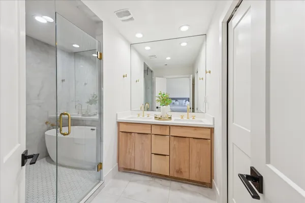 a bathroom with a double vanity sink mirror and shower