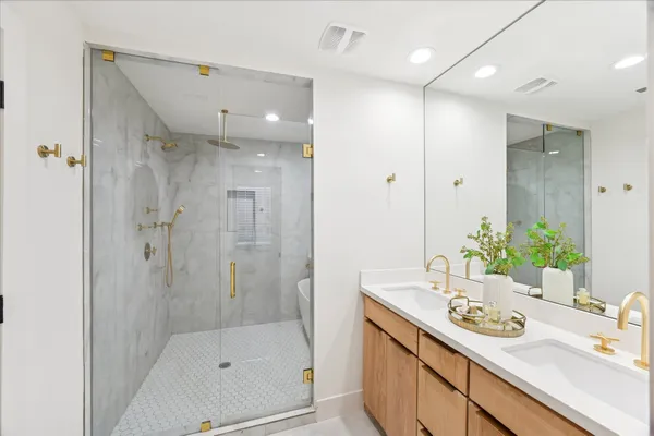 a bathroom with a sink shower and a mirror