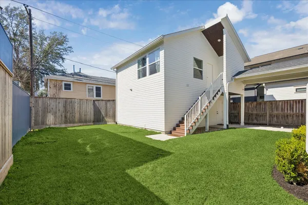 a view of a house with a yard and stairs