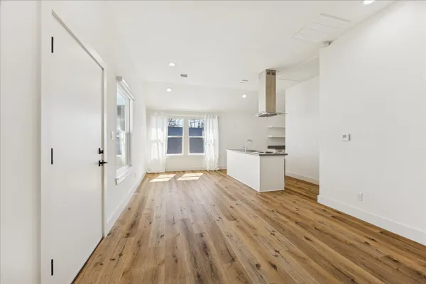 a view of a kitchen with wooden floor and windows