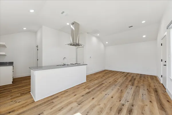 a view of empty room with wooden floor
