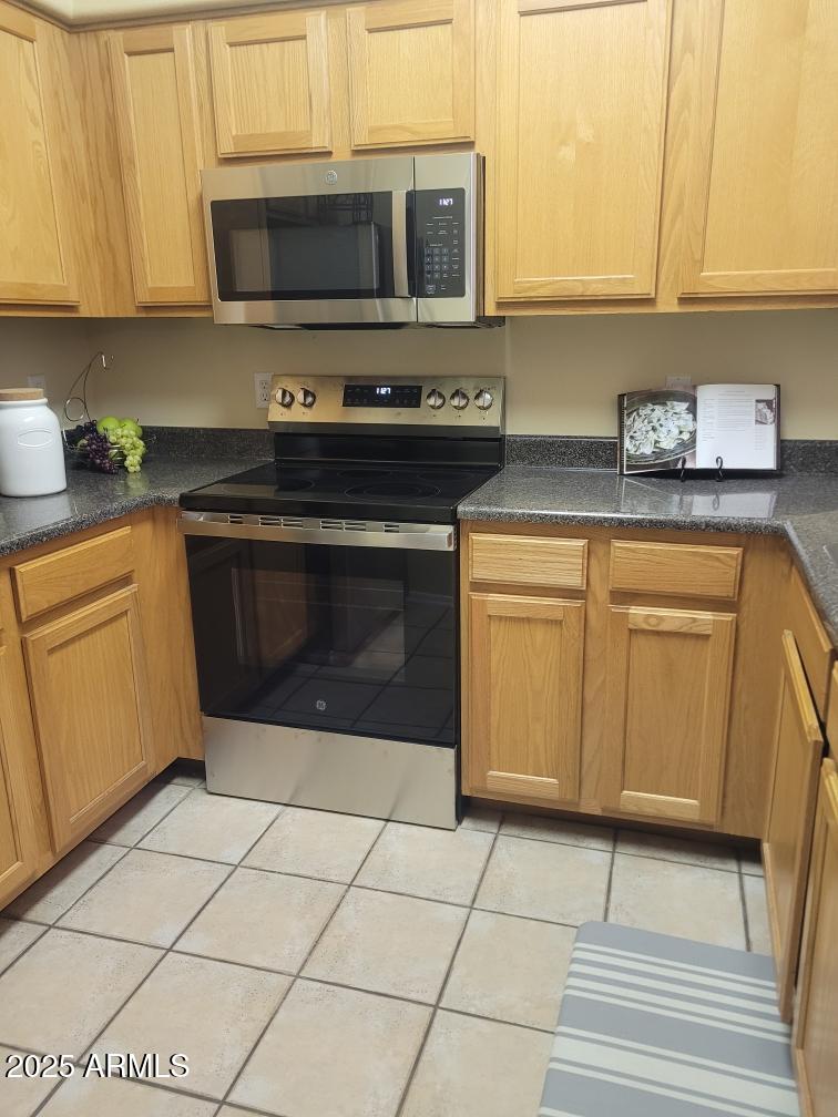 20100 North 78th Place, Unit 2203 Scottsdale, AZ 85255 - Photo 12 of 35 a kitchen with stainless steel appliances granite countertop a stove a microwave and a sink